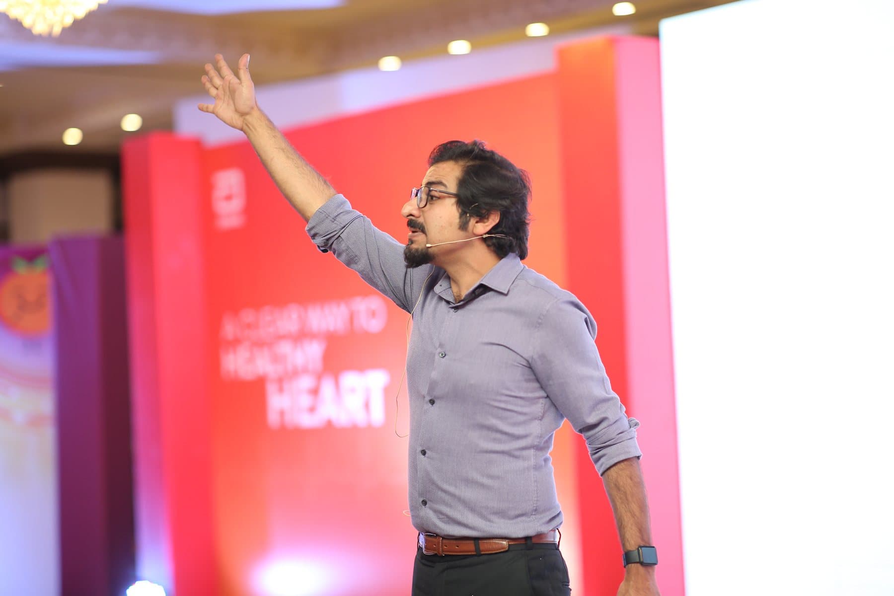 Umair delivering a keynote on stage at Abbott's 'A Clear Way to a Healthy Heart' event
