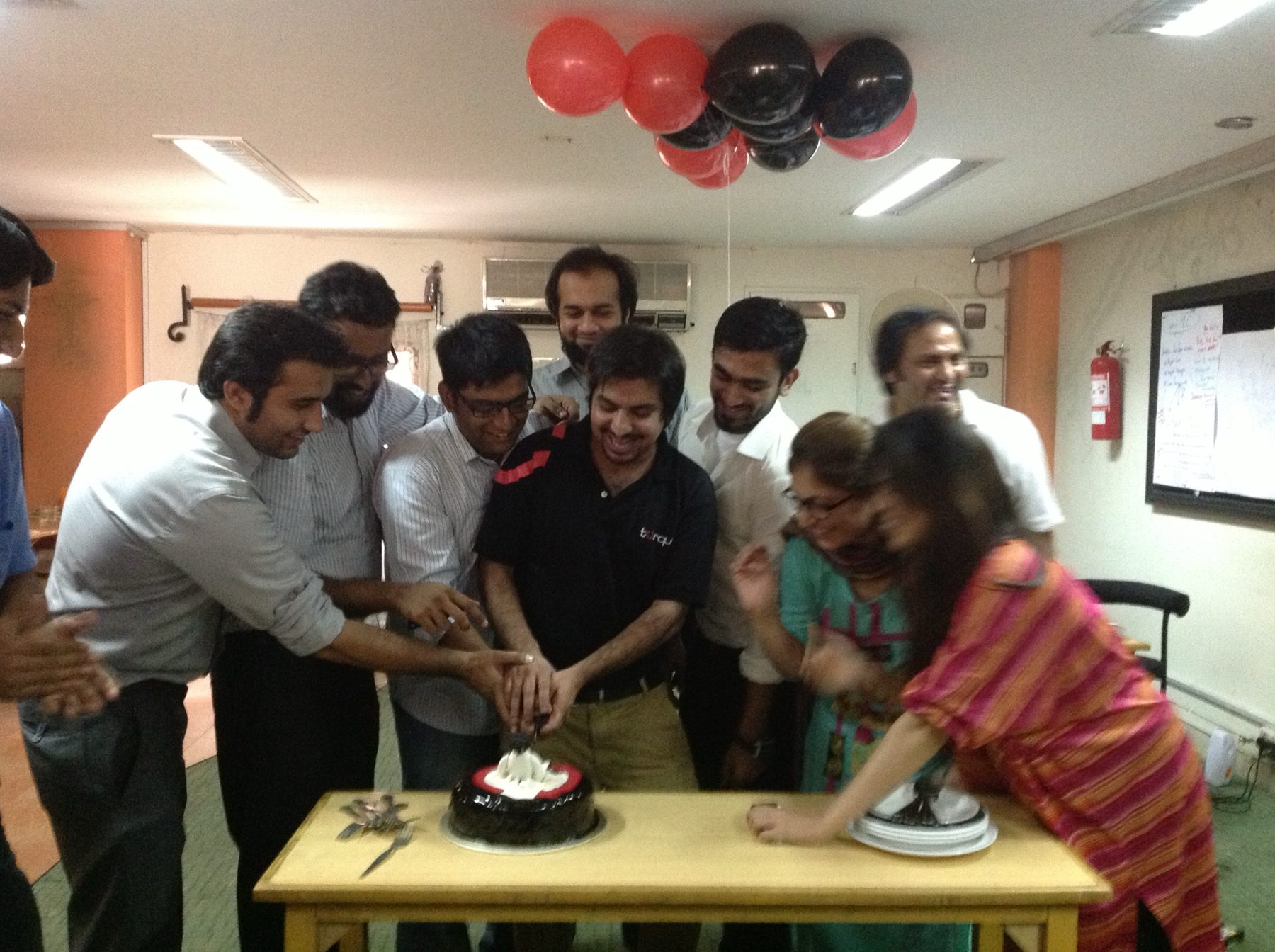 Umair and the Torque team cutting a Torque cake together